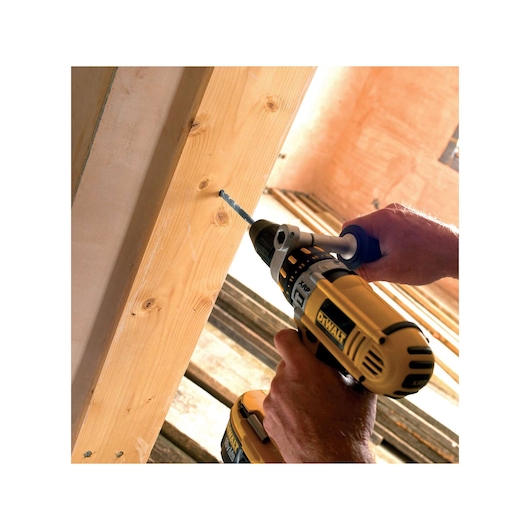 A DEWALT cordless drill is used to drill a hole in a wooden beam during construction work.