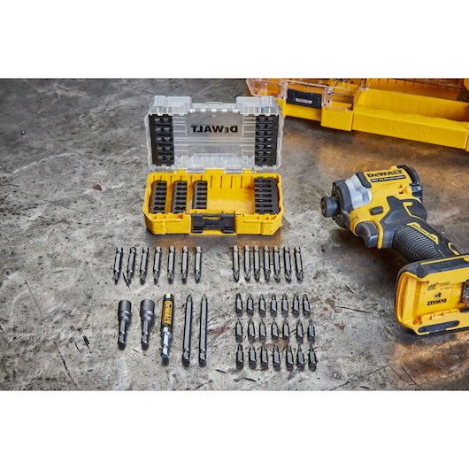 DEWALT drill and bit set with yellow case, multiple bits arranged on a workshop table.