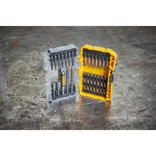 Open DEWALT DT70702 case showing assorted screwdriver and drill bits on a metal surface.