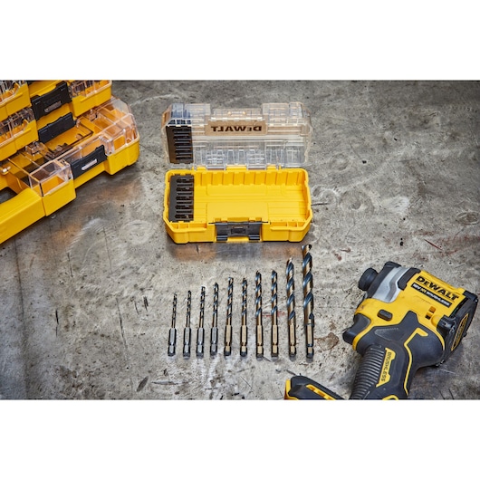 DEWALT drill and bit set with yellow storage case on a metal surface, bits arranged by size.