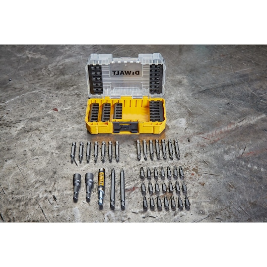 DEWALT DT70702 drill bit set in a yellow plastic case, with various drill bits arranged on a work surface.