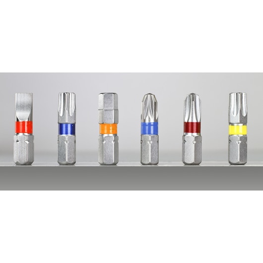 Six DEWALT screwdriver bits with colored bands, arranged upright on a gray surface, various tip shapes shown.