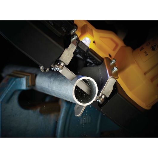 Close-up of a DEWALT saw cutting a metal pipe held in a vise.