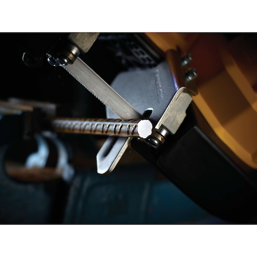Close-up of a DEWALT saw cutting through a metal rebar in a workshop setting.