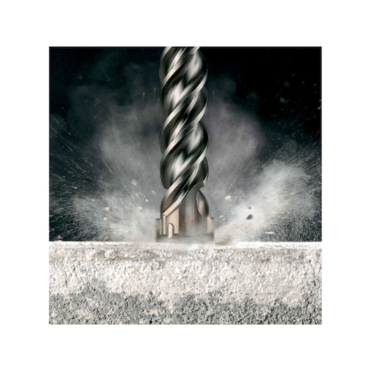 Close-up of a DEWALT drill bit impacting concrete, creating dust and debris.