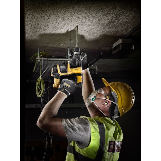 Worker using DEWALT DT9541, DT9541-QZ drill on ceiling at jobsite. Photography product category.
