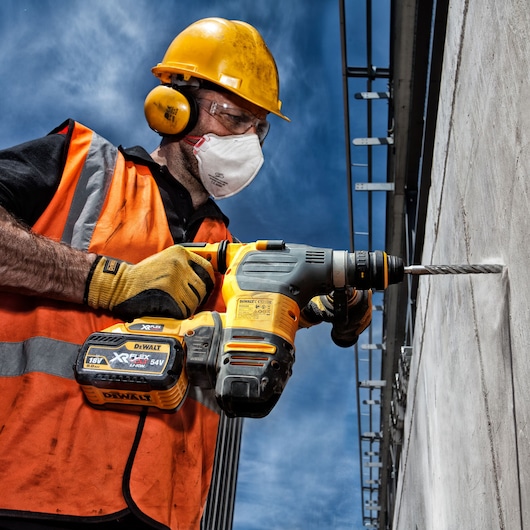DEWALT drill DT9580, DT9580-QZ used by worker on concrete wall. Photography product.