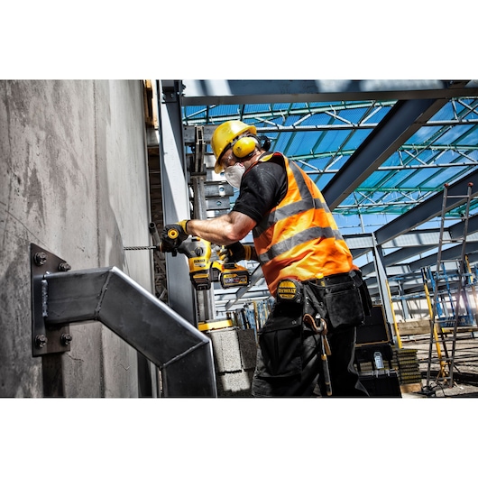 DEWALT DT9619-QZ, DT9619 drill bit used at a construction site; worker drills into concrete wall.
