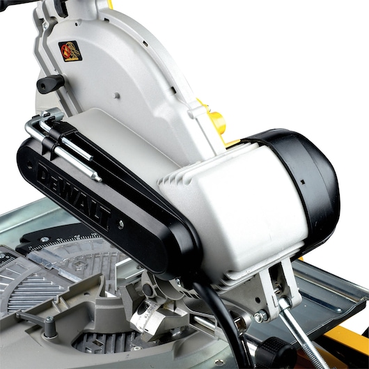 Close-up of a DEWALT DW743N mitre saw, showing the mechanical details and branded arm component.