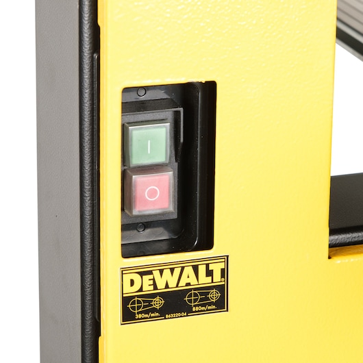 Close-up of the DEWALT DW876 machine control panel with green and red power switches on yellow casing.