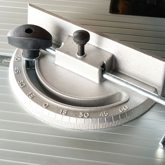 Close-up of a DEWALT metal angle guide with degree markings, used for precision cutting adjustments.