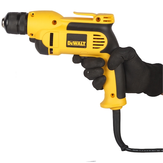 A person wearing a black glove holds a yellow and black DEWALT electric drill with a cord, shown against a white background.