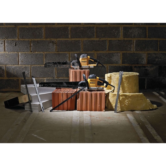 Two DEWALT saws on bricks, insulation, and blocks in front of a brick wall, displayed with construction materials.