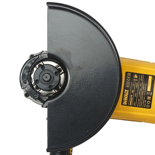 Close-up of DEWALT DWE4579 angle grinder with black guard and yellow label showing technical information.