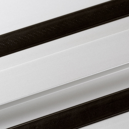Close-up of a DEWALT DWS5022 metal guide rail with two black slip-resistant strips.