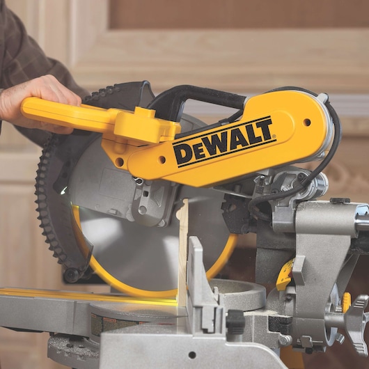 DEWALT DWS780, DWS780KIT miter saw in use, cutting wood. Photography category.