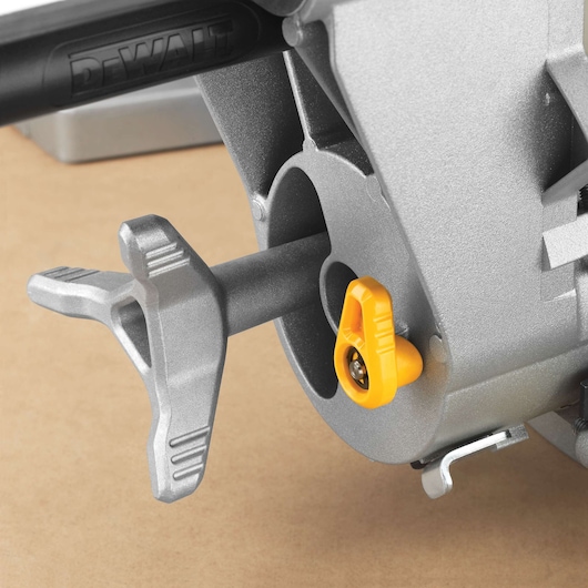 DEWALT saw part close-up from DWS780, DWS780KIT. Photography category. Metal and yellow adjustment knobs.