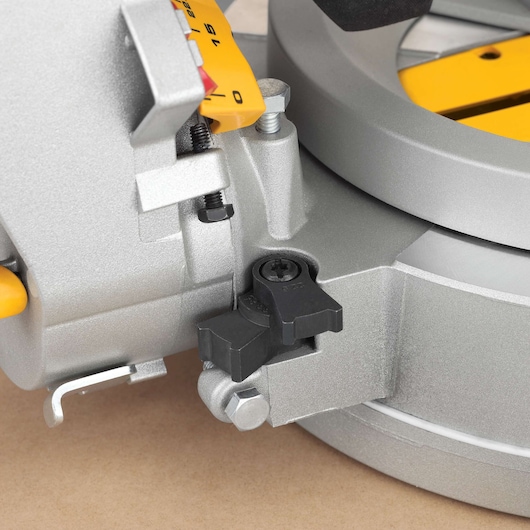 Close-up view of the DEWALT DWS780 miter saw, focusing on the adjustment knob and angle scale for precise cutting.
