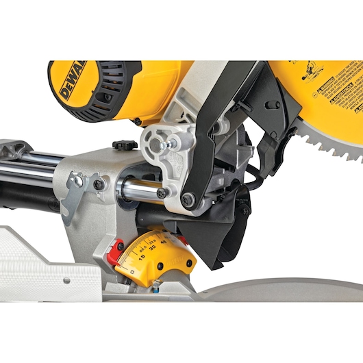 Close-up view of a DEWALT DWS780 sliding compound miter saw, showing the saw blade, bevel gauge, and adjustment mechanisms.