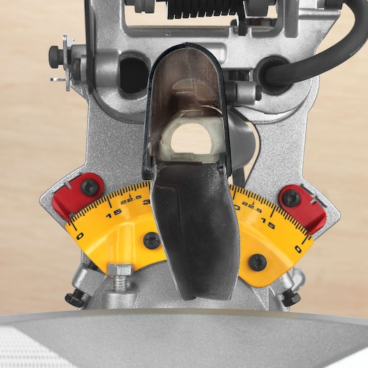 Close-up view of a DEWALT DWS780 miter saw, focusing on the adjuster dial with yellow angle markings and two red stops for precise cutting adjustments.
