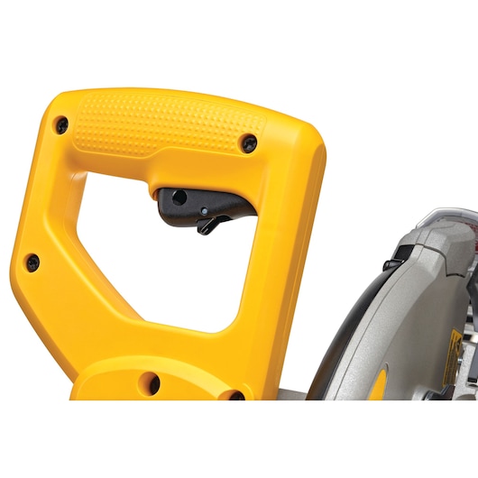 Close-up view of the yellow handle and trigger of a DEWALT miter saw, showing part of the saw blade and housing.