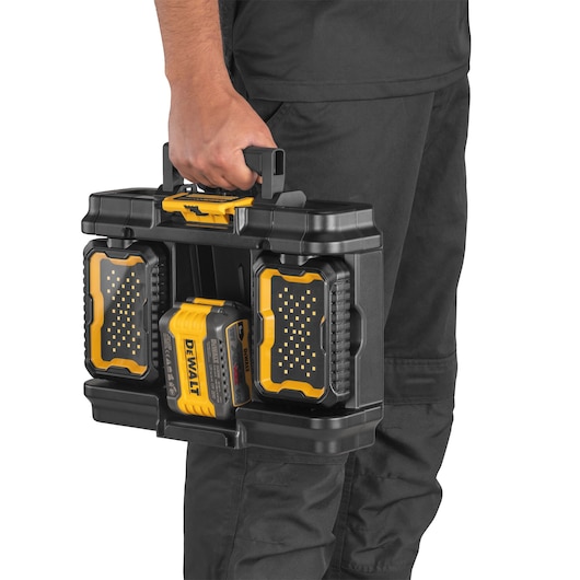 A person holding a DEWALT DWST08061-1 portable black and yellow hard case with integrated LED lights and a battery pack. The case is designed for easy carrying and storage of photography equipment.