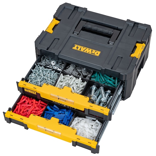 DEWALT organiser box with two open drawers containing assorted screws, bolts, and plastic wall plugs.