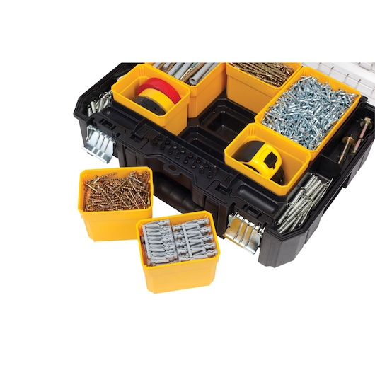 DEWALT organizer box with yellow compartments holding screws, wall plugs, tape, and other hardware.
