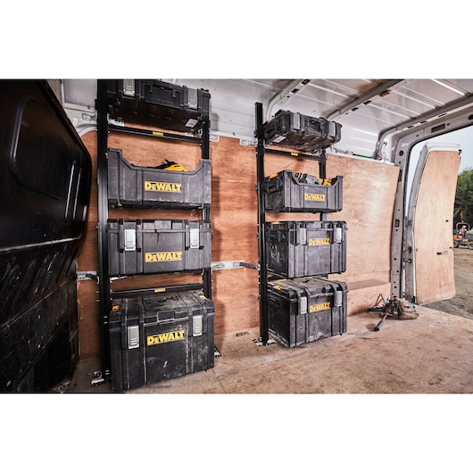 DEWALT tool storage boxes organized on metal racks in a van, used for secure transport and easy access.
