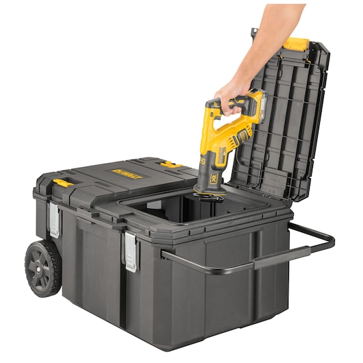 DEWALT rolling toolbox with open lid; a hand places a yellow power tool inside the box.