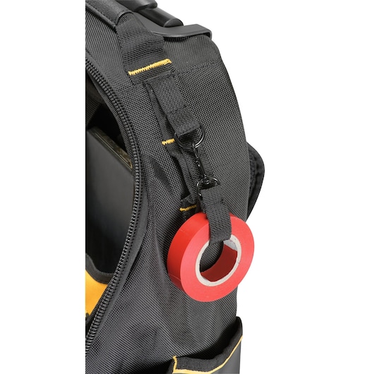 Close-up of a black DEWALT tool bag with a roll of red tape attached to a strap with a clip.
