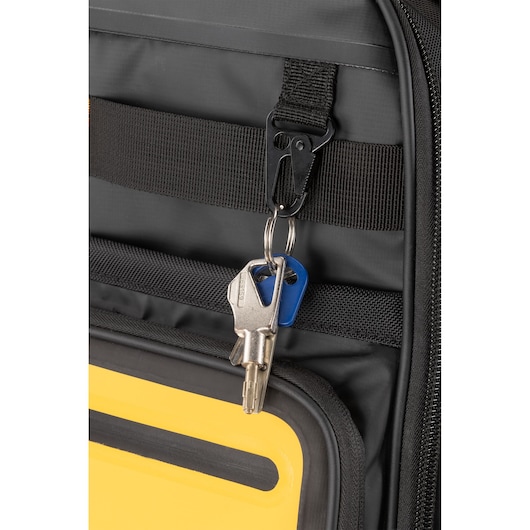 Close-up of a set of keys attached to a black carabiner clip on a black and yellow DEWALT bag.