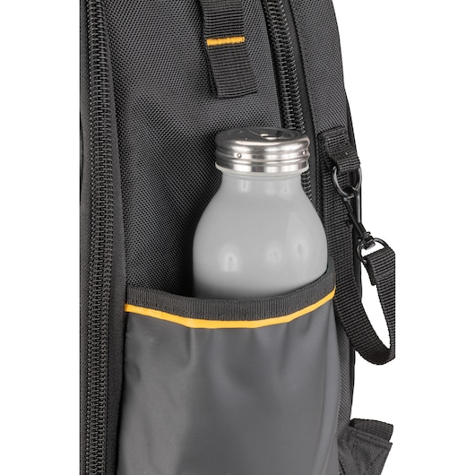 Close-up of a grey water bottle with a metal cap in the side pocket of a black DEWALT backpack, featuring yellow trim.