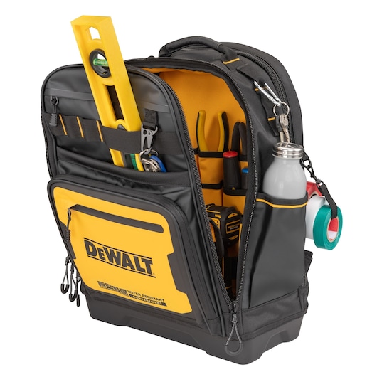 A DEWALT branded black and yellow tool backpack with multiple compartments and pockets, containing various tools including a spirit level, pliers, screwdrivers, tape measure, water bottle, and rolls of adhesive tape.