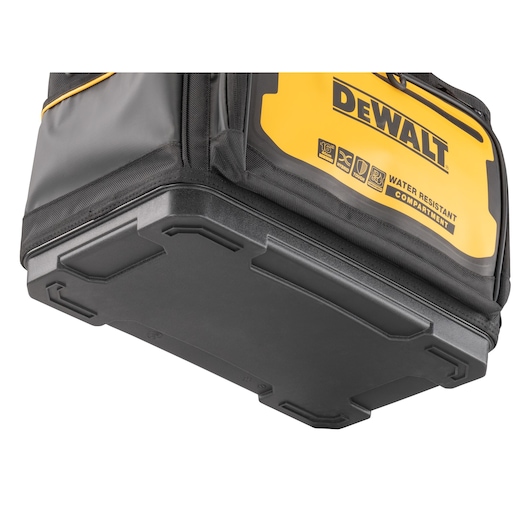 Close-up view of the hard plastic base of a DEWALT tool bag, showcasing its reinforced water-resistant compartment.