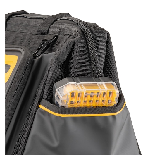 Close-up of a DEWALT black tool bag with a yellow and transparent plastic case in the outer pocket.