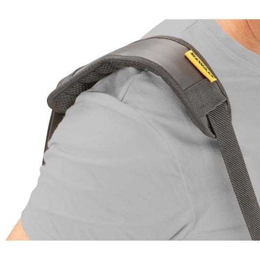 Close-up view of a DEWALT shoulder strap with padded support, worn over a light grey shirt.