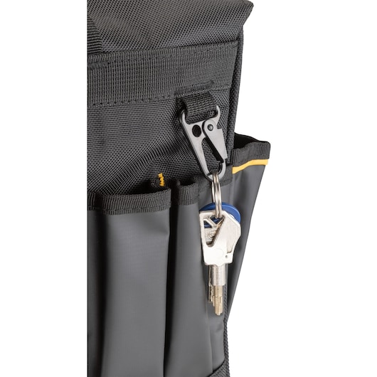 Close-up of a black DEWALT tool bag with a metal key ring attached to a clip and keys in one of the front pockets.