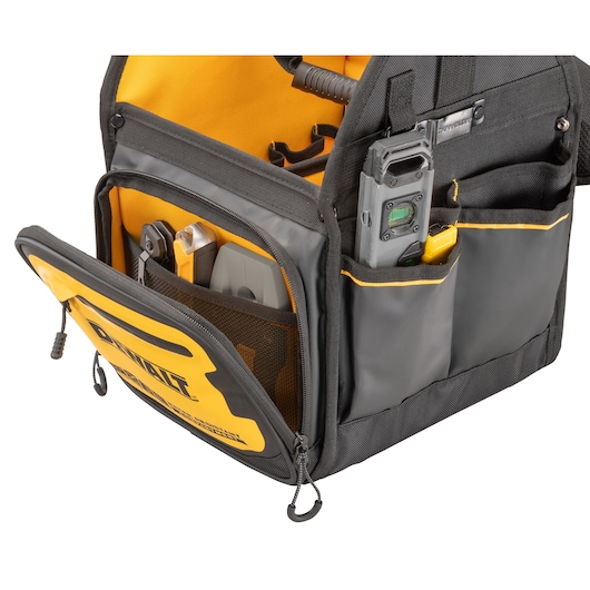 A close-up view of a DEWALT black and yellow tool bag with multiple compartments and pockets, showing various tools organized inside.