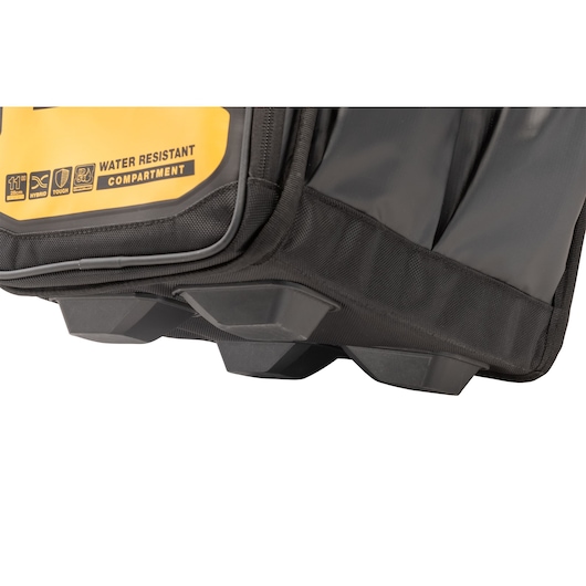 Close-up view of the base of a DEWALT tool bag showing its durable, reinforced plastic feet and water-resistant compartment label.
