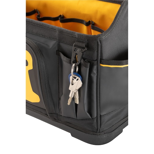 Close-up of a black and yellow DEWALT tool bag showing a set of keys attached to a key clip on the outside pocket.