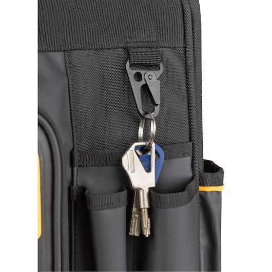 Close-up of a black DEWALT tool bag with a metal clip holding a set of keys attached to the exterior pocket.