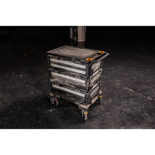 DEWALT rolling tool chest with three drawers and wheels on a dark floor.