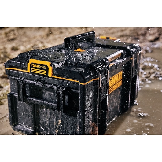 DEWALT ToughSystem toolbox in wet, muddy conditions showing water-resistant durability.
