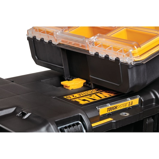 Close-up of DEWALT ToughSystem 2.0 tool storage with yellow compartments and clear lid.