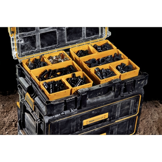 Open DEWALT ToughSystem box with yellow compartments holding assorted hardware and connectors.
