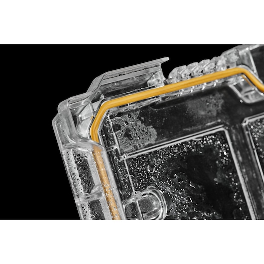 Close-up of a DEWALT case lid with yellow seal and water droplets for photography equipment protection.