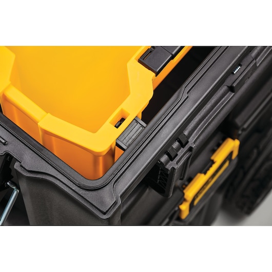 Close-up of a DEWALT black toolbox with a yellow removable insert inside.