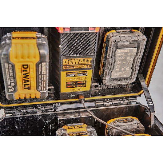 DEWALT ToughSystem 2.0 charger and batteries in a rugged storage case, showing charging ports and battery slots.