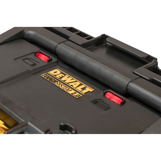 Close-up of a DEWALT ToughSystem 2.0 toolbox lid showing handle and two red latches.